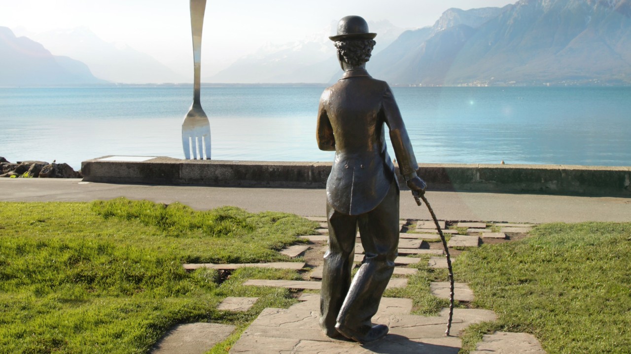 Eine in den See gestochene Gabel und die Rückansicht der Chaplin-Statue sind von der Promenade aus zu sehen.
